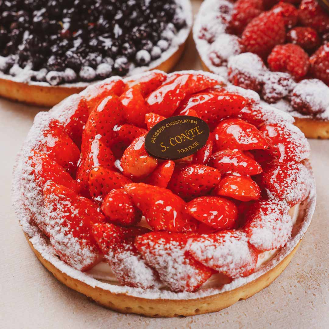 Tarte aux fraises et tarte myrtilles et framboises en arrière plan